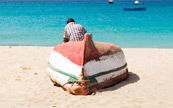 Homme assis devant sa barque sur l'le du Cap-Vert